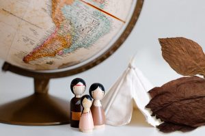 Ilustračný obrázok: história tabaku - glóbus, drevené postavičky reprezentujúce indiánov, maketa wigwamu a sušený tabakový list