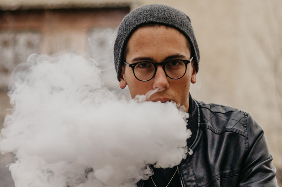Mladý muž vydychuje hustý dym