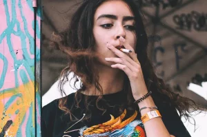 Mladá žena fajčí cigaretu