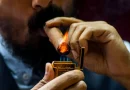 Fajčenie cigary - detail na muža s bradou zapaľujúceho si cigaru