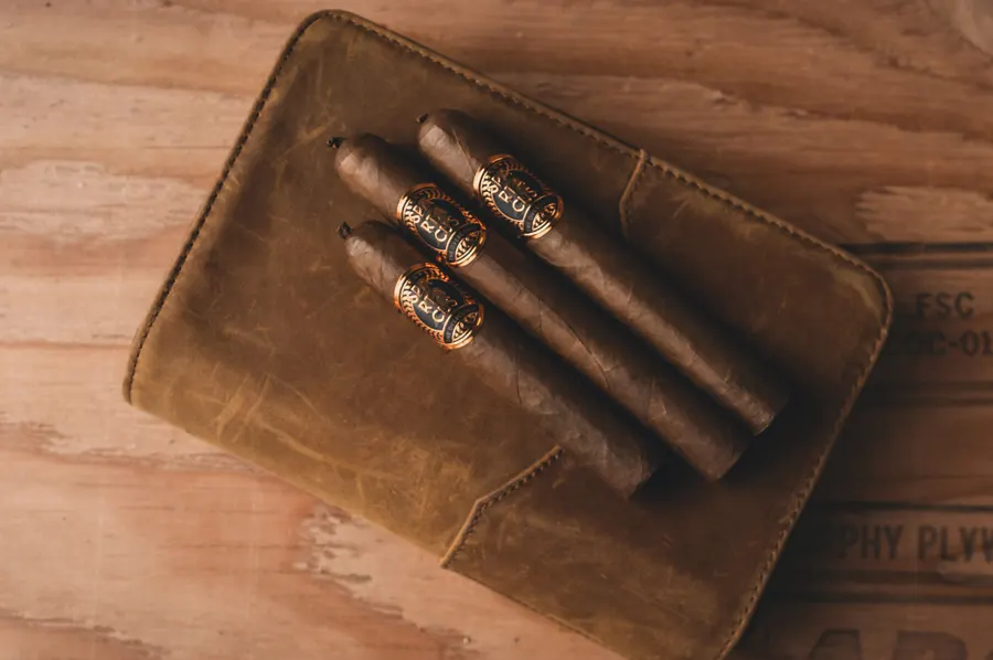 Tri cigary položené na koženom puzdre