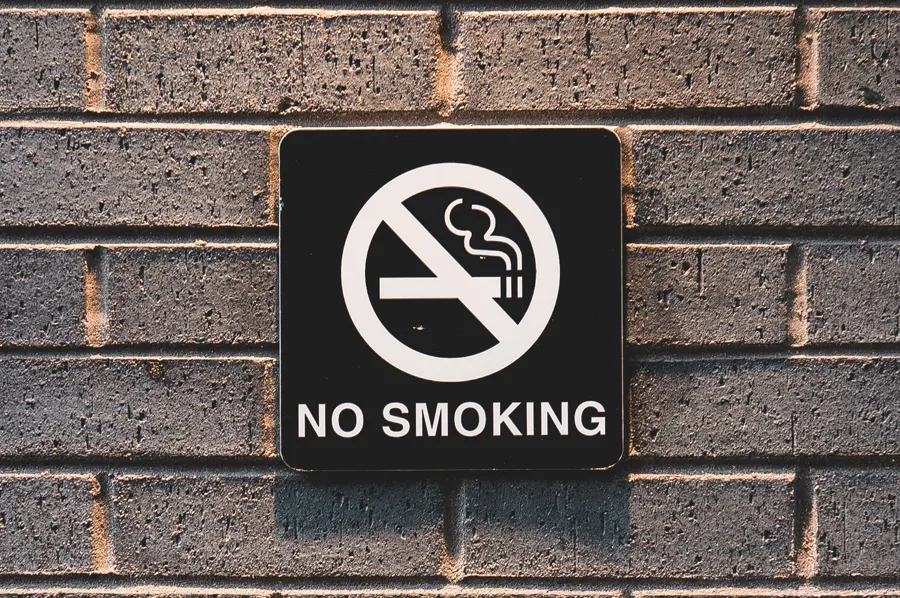 Zákaz fajčiť - informačná ceduľa na tehlovej stene