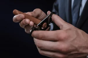 Cigarový orezávač v mužských rukách: orezávanie cigary