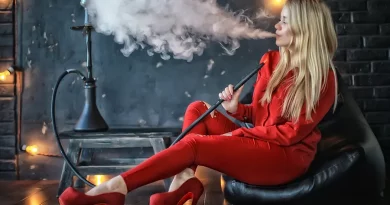 Mladá blind žena v červenom oblečení fajčí vodnú fajku a vydychuje dym
