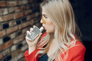 Mladá žena si poťahuje z elektronickej cigarety
