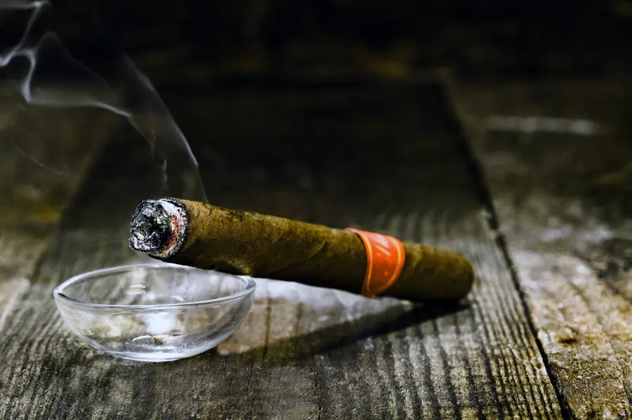 Horiaca cigara v sklenenom popolníku