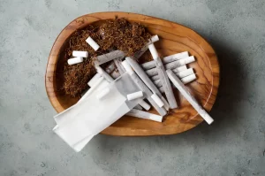 Skladovanie tabaku - tabak, cigarety, filtre a papieriky v drevenej miske
